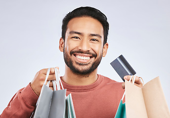 Image showing Shopping bag, portrait and man with happiness, credit card and smile for retail fashion spree, sales or Black Friday deal. Promotion face, studio payment and happy male customer on white background