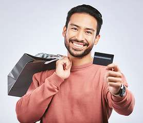 Image showing Shopping bag, portrait or man with smile, debit card and happiness for retail fashion spree, sales discount or boutique deal. Promotion face, studio credit payment or happy person on white background