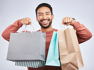 Image showing Shopping bag, studio portrait and happy man customer or client with retail product, gift or fashion spree choice. Boutique discount deal, market present and excited person smile on white background