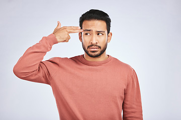 Image showing Frustrated, depression and man with gun gesture or stress with mental health or emotion in grey background in studio. Male person, shooting and head with anger or problem with anxiety and fear.