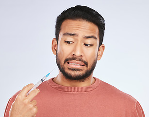 Image showing Fear, vaccine and face of asian man in studio with needle, phobia or covid scare on grey background. Corona, compliance and male person afraid of vaccination, medicine or prescription diabetic shot