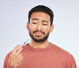 Image showing Vaccine, fear and face of asian man in studio with needle, phobia or covid scare on grey background. Corona, compliance and male person afraid of vaccination, medicine or prescription diabetic shot