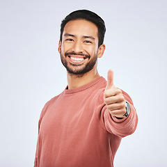 Image showing Thumbs up, portrait and happy asian man in studio, white background and thank you. Male model, thumb emoji and smile of winner, achievement and celebration of feedback, good review and yes with hands