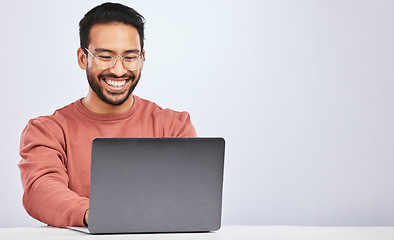 Image showing Business, smile and asian man with laptop on studio for research, typing or social media on grey background. Happy, search and male freelancer online for design, blog or project, creative or planning