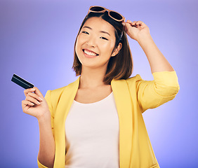 Image showing Credit card, sunglasses portrait and woman shopping, retail banking and finance, e commerce or paperless payment. Happy customer, model or asian person with fashion loan on studio, purple background