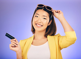 Image showing Credit card, shopping portrait and woman in sunglasses, retail banking and finance, e commerce or payment. Happy customer, fashion model or asian person for debit pay on studio purple background