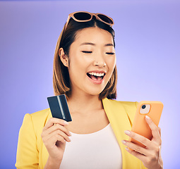 Image showing Credit card, phone and woman online shopping, e commerce or fintech payment on studio purple background. Excited, loan and happy asian person for internet banking, subscription or mobile transaction