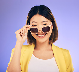 Image showing Happy asian woman, portrait and sunglasses for fashion or stylish accessory against a purple studio background. Female person or model with smile in satisfaction or relax for summer style or clothing