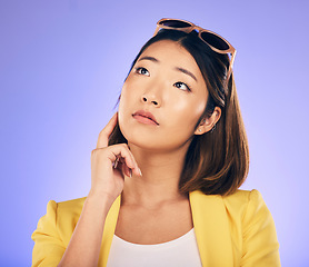 Image showing Decision, idea and asian woman with wonder or choice with purple background in studio with glasses. Contemplating, girl and vision or thoughtful face with doubt for option or solution on mind.