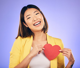 Image showing Girl, smile and heart for care in portrait for purple background in studio with asian on valentines day. Support, love and chest with female person with happiness with emoji shape or emotion.