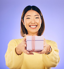 Image showing Portrait, smile and Asian woman with a gift, box and celebration against a studio background. Face, happy female person or model with happiness, present and giveaway with a ribbon, surprise and prize