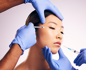 Image showing Woman, needle and hands on face for plastic surgery in studio, change and collagen for cosmetic results by background. Japanese model, girl and syringe for lip filler, doctors and transformation