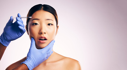 Image showing Asian woman, hands and needle for plastic surgery in studio for cosmetics, mockup space or collagen on a white background banner. Beauty, doctor and syringe for patient, change with pain on face