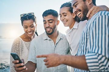 Image showing Friends, together and phone at ocean with laughing or meme on holiday or weekend to relax. Cellphone, beach and couple with group are happy on vacation with social media in summer for fun in outdoor.