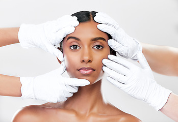 Image showing Woman, plastic surgery and hands in studio portrait with beauty, skincare and face with process by white background. Change, model and doctors gloves for transformation, cosmetics or facial aesthetic