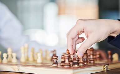 Image showing Chess, board game and hand of a man playing at a table while moving piece for strategy or checkmate. Person with wooden icon to play, relax and bond or problem solving and battle in competition