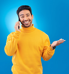 Image showing Happy, conversation and portrait of an Asian man on a phone call for communication and networking. Smile, technology and a person speaking on a mobile isolated on a blue background in a studio