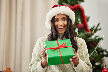 Image showing Christmas, portrait or happy girl with a gift box or present on a holiday celebration at home in winter. Guessing, smile or excited Indian woman with package with festive or xmas parcel in a house