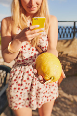 Image showing Phone, social media and woman hands with lemon on holiday with photography and online on vacation. Young female person, mobile and freedom with produce photo in a city outdoor with citrus in Italy