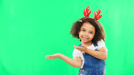 Image showing Christmas, green screen and a girl presenting advertising space for product placement in studio. Portrait, kids or celebration with an adorable little child on chromakey mockup for the festive season