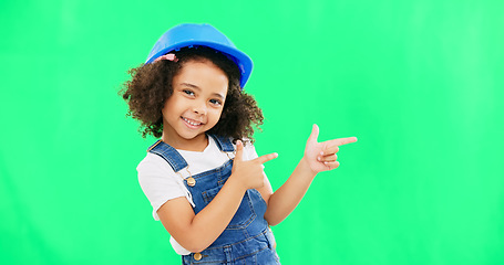 Image showing Children, construction and a girl on a green screen background in studio pointing at building space. Kids, architecture and design with a cute female child engineer wearing a hardhat on chromakey