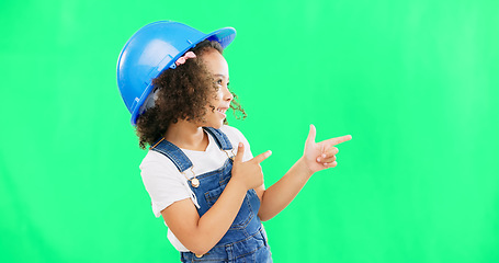 Image showing Children, construction worker and a girl on green screen background in studio pointing at building space. Kids, architecture or design with a cute female child engineer wearing a hardhat on chromakey