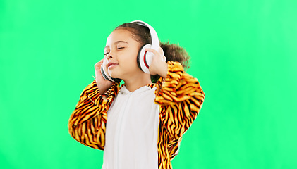 Image showing Children, music and dance with a girl on a green screen background in studio streaming audio while having fun. Kids, energy and freedom with a little female child dancing while listening to the radio