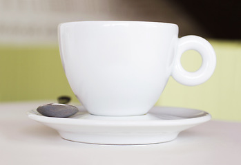 Image showing Closeup, white cup and saucer in cafe, coffee shop and order for hot drinks beverage. Background, table crockery and teacup for drinking latte, cappuccino and espresso in restaurant or food industry