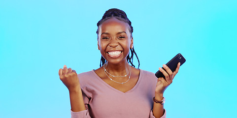 Image showing Wow, happy and excited black woman with phone receiving email news of bonus, promotion or announcement in studio. Winning, prize notification and African girl celebrating with smile on blue backgrou