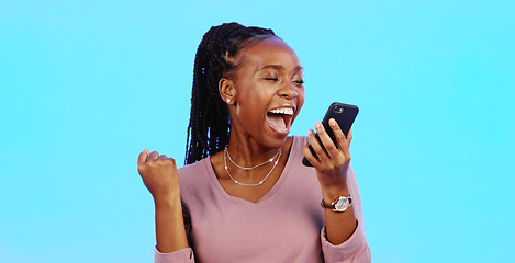 Image showing Wow, happy and excited black woman with phone reading email news of bonus, promotion or announcement in studio. Winning, prize notification and African girl celebrating with smile on blue background