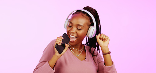 Image showing Sing, dance and black woman with headphones music microphone isolated on a studio background. Fun, happy and funky African girl listening to audio, radio or songs while singing and dancing on a backd