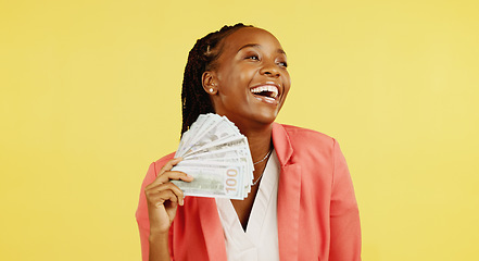 Image showing Money, fan and winner with a black woman in studio on a yellow background holding cash, finance or wealth. Financial, investment and trading with dollar bills in the hand of a female after winning