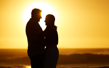 Image showing Silhouette, couple and love at sunset on beach for vacation, holiday or mockup outdoor. Romantic man and woman hug in nature with creative sky background for affection, shadow art and travel freedom