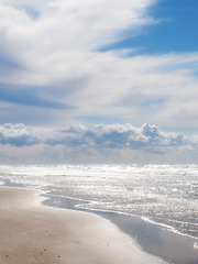 Image showing Beach, clouds and blue sky by the ocean for travel with a seascape or tropical vacation in Australia. Nature, island and sea water waves with sand for an outdoor paradise holiday or weekend trip.