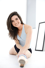 Image showing Stretching legs, ballet and portrait of woman training in studio sitting on floor. Ballerina stretch, face and happy athlete from Canada warm up for exercise, dance and fitness, workout and practice.