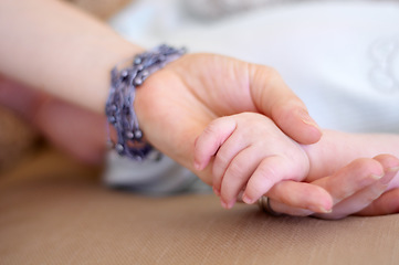 Image showing Love, family and mother holding hands with her baby in the home for trust, care or bonding together closeup. Children, hand or comfort with a mama and newborn infant in a house to nurture growth