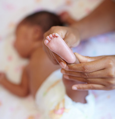 Image showing Hands, infant and closeup of a baby foot with mother holding for comfort, care and love. Childcare, cute and zoom of a woman touching her newborn girl child feet in her crib in the nursery at home.