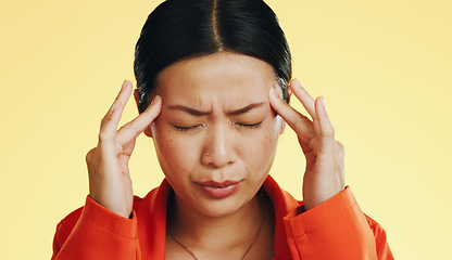 Image showing Asian woman, headache and studio with stress, migraine and hands on head to massage temple by background. Young japanese model, pain and anxiety with mental health, fatigue and burnout by backdrop