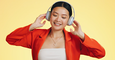 Image showing Dance smile, music headphones and Asian woman in studio isolated on a yellow background. Technology, podcast or happy female streaming, listening and dancing to radio, song and audio, sound and album
