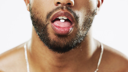 Image showing Man, mouth and hands with pill, drug or medication for relief, healthcare or substance abuse against a white studio background. Lips and tongue of male addict taking medical supplement vitamin tablet