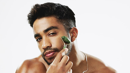 Image showing Face, man and facial roller for skincare, cosmetics and wellness against a grey studio background. Portrait, male and guy with rose quartz, massage and salon treatment for smooth, soft and clear skin