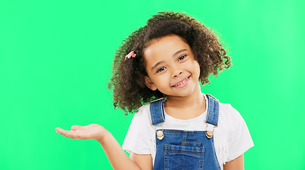 Image showing Happy, little girl and green screen with smile for product placement isolated against a studio background. Portrait of cute female kid smiling with palm of open hand showing advertisement on mockup