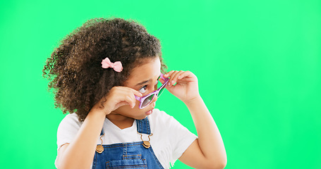 Image showing Green screen, fashion and child looking with sunglasses for trendy, stylish clothes and accessories. Emoji face, happy and portrait of girl with funny, comic and humour facial expression in studio