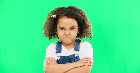 Image showing Child, angry and face with arms crossed on green screen with attitude, problem or frustrated in studio. Black kid or girl with mad, grumpy and upset or annoyed facial expression with brat tantrum