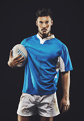Image showing Rugby, black background and portrait of man athlete with ball in dark studio while training in dirt for wellness and fitness. Exercise, workout and professional sports career of male person or player