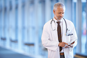 Image showing Typing, happy and a doctor with a tablet for healthcare, consulting and cardiology. Hospital, smile and a mature surgeon or medical consultant with tech for a clinic schedule, agenda or planning