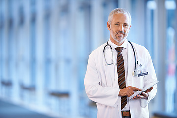 Image showing Portrait, healthcare and tablet with a senior doctor standing in a hospital corridor for research or insurance. Medical, trust and technology with a man medicine professional in a clinic for health