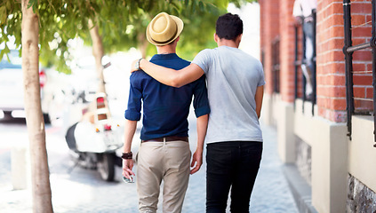 Image showing Travel, city and back of men walking in the road together while embracing on a tourism weekend trip. Affection, sightseeing and male friends in an urban street of a town on a holiday or vacation.