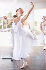 Image showing Girl ballerina pose at barre, ballet and dance class with young dancer learning balance and art at studio. Female child in lesson at academy, creativity with fitness and training, elegance and focus