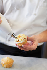 Image showing Closeup baker hands, frosting and cupcake for decoration, dessert and cooking with professional chef. Bakery, cream and muffin on table for restaurant, cafe or coffee shop with food for breakfast